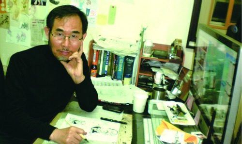 작업실 책상 앞에 앉은 안세희 작가